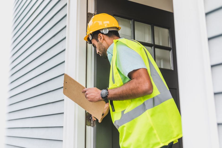Inspector reviewing a home’s basement systems with buyers beside a written inspection report